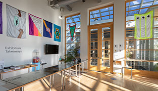 Another view of the same room, with another flag hanging in front of a glass wall partitioning the room from a corridor.