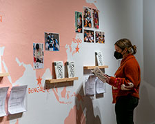 A woman reads a zine at the installation of the world map.