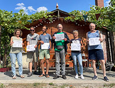 A group of Berliners holding their drawings in a community garden.