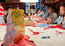 Teenagers making paper dolls in a library in NYC.
