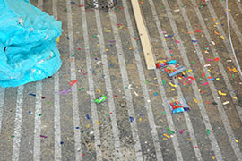 a photo of part of piñata and confetti on the ground