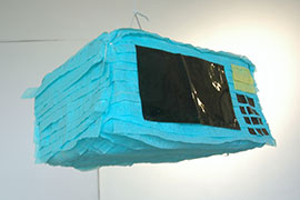 a piñata of a microave, made of blue streamers and black vinyl