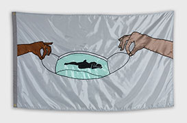 Photo of a flag of the same design as the previous image. The mask is green, and the background is light grey. The hands are shades of light brown.