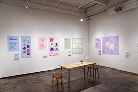 gallery installation with different colored activity areas on the back wall and wall at right.