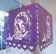 A lantern in light violet which shows a young woman looking in the mirror where her reflection is surrounded by community members.