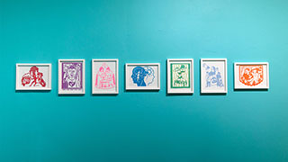 A row of several papercuts framed in white frames