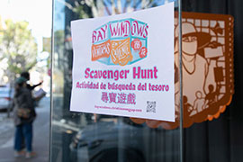 Flyer for the Scavenger hunt taped to a window, with a lantern and viewers in the background